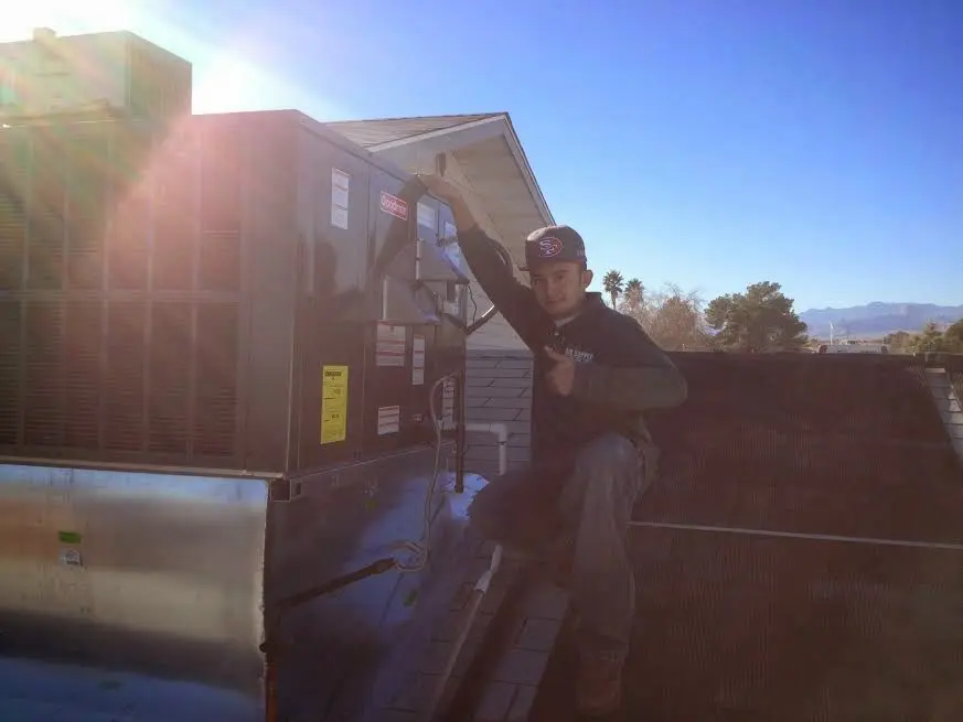 HVAC technician performing AC Tune-Up on a rooftop unit in Dunmore